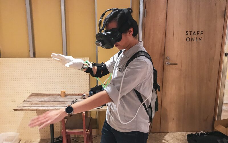 Player in a VR headset wearing the thermal glove and backpack