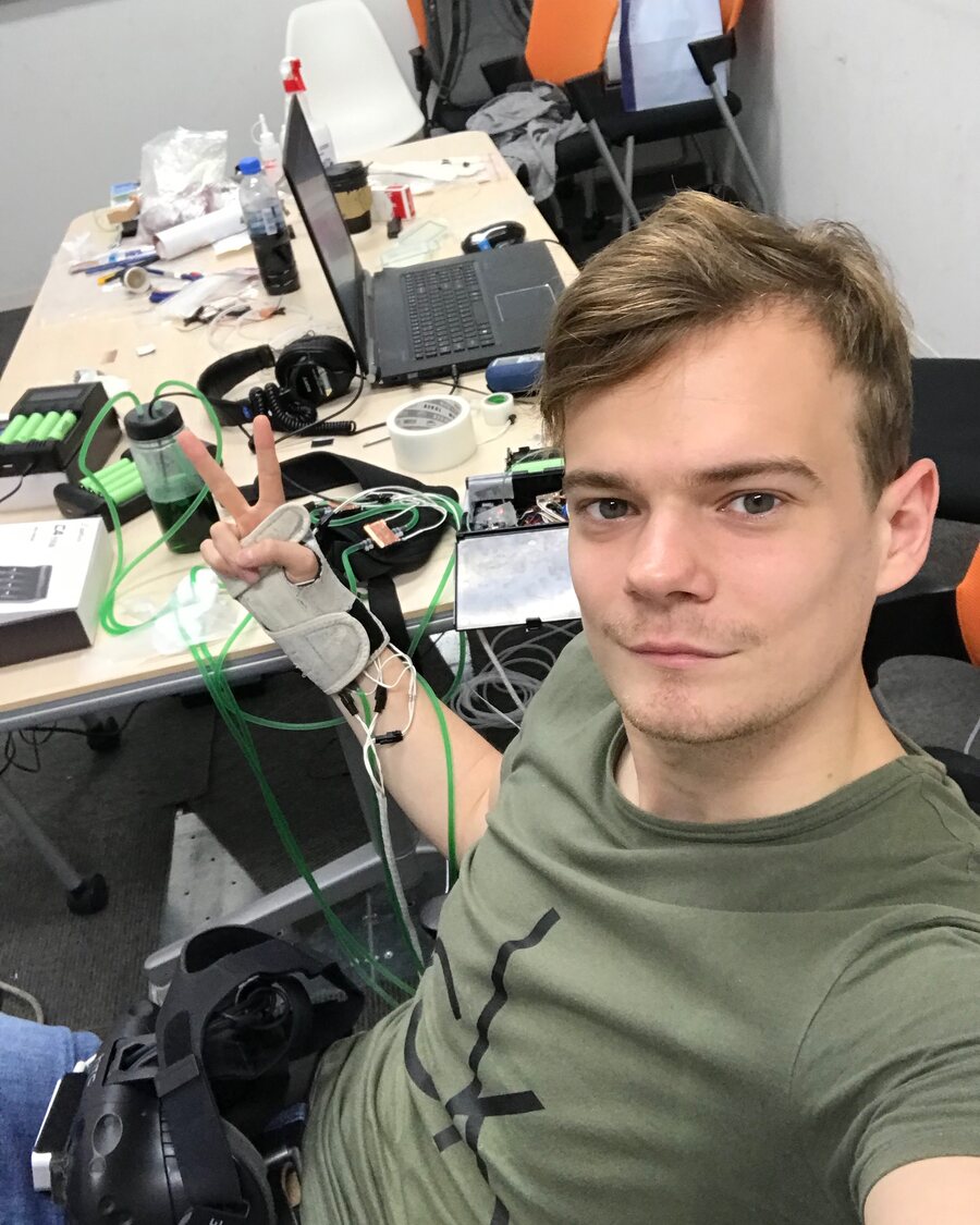 Kirill Ragozin at a lab desk, wearing a prototype thermal glove